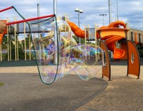 Un enfant fait de grandes bulles de savon dans un terrain de jeu à Tel Aviv un jour nuageux photos stock Un enfant fait de grandes bulles de savon dans un terrain de jeu à Tel Aviv un jour nuageux photos stock