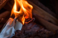 Un foglio di carta che brucia con una fiamma luminosa arancio rossa con calore immagini stock Un foglio di carta che brucia con una fiamma luminosa arancio rossa con calore immagini stock