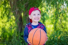 Un garçon heureux remettant un basket-ball, photo libre de droits Un garçon heureux remettant un basket-ball, photo libre de droits