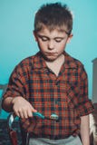 Un garçon triste dans des pyjamas n'est pas désireux pour se brosser les dents avant d'aller dormir sur un fond bleu photos stock Un garçon triste dans des pyjamas n'est pas désireux pour se brosser les dents avant d'aller dormir sur un fond bleu photos stock