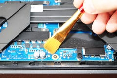 Un geek pulisce un dispositivo di raffreddamento del computer portatile Sistema di raffreddamento contaminato del computer fotografia stock Un geek pulisce un dispositivo di raffreddamento del computer portatile Sistema di raffreddamento contaminato del computer fotografia stock