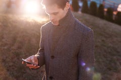 Un giovane uomo d'affari bello facendo uso del suo telefono fotografia stock libera da diritti Un giovane uomo d'affari bello facendo uso del suo telefono fotografia stock libera da diritti