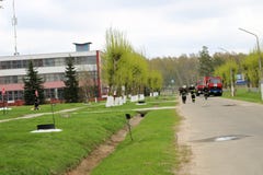 Un grand véhicule de sauvetage du feu rouge, un camion pour s'éteindre un feu et des sapeurs-pompiers de mâle à un produit chimiq photos stock Un grand véhicule de sauvetage du feu rouge, un camion pour s'éteindre un feu et des sapeurs-pompiers de mâle à un produit chimiq photos stock