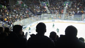 Un groupe de silhouettes de match de observation d'hockey des jeunes dans un stade fermé photos stock Un groupe de silhouettes de match de observation d'hockey des jeunes dans un stade fermé photos stock