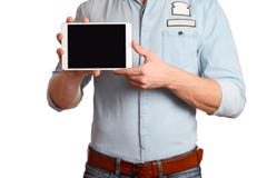 Un hombre en una camisa azul clara y vaqueros con una correa marrón está sosteniendo la PC de la tableta aislada en el fondo blan imagen de archivo Un hombre en una camisa azul clara y vaqueros con una correa marrón está sosteniendo la PC de la tableta aislada en el fondo blan imagen de archivo