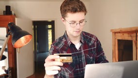 Un hombre hace una compra en línea con una tarjeta de crédito metrajes Un hombre hace una compra en línea con una tarjeta de crédito metrajes