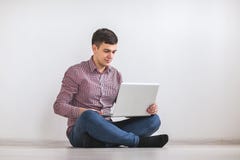 Un hombre joven que trabaja en una computadora portátil fotografía de archivo Un hombre joven que trabaja en una computadora portátil fotografía de archivo