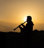 Un hombre no identificado juega el clarinete en la puesta del sol fotos de archivo Un hombre no identificado juega el clarinete en la puesta del sol fotos de archivo