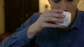 Un hombre que bebe té o el café durante el trabajo almacen de metraje de vídeo Un hombre que bebe té o el café durante el trabajo almacen de metraje de vídeo