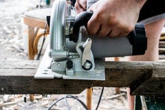 Un hombre trabaja con sus manos y una herramienta de la construcción Eléctrico vio Trabajo sobre los tableros de madera Para cort fotografía de archivo Un hombre trabaja con sus manos y una herramienta de la construcción Eléctrico vio Trabajo sobre los tableros de madera Para cort fotografía de archivo