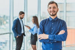 Un homme d'affaires se tient dans le bureau a plié sa main à sa main Pendant ce temps, il se tient sur le fond photos libres de droits Un homme d'affaires se tient dans le bureau a plié sa main à sa main Pendant ce temps, il se tient sur le fond photos libres de droits