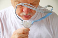 Un homme plus âgé tient le couvre-chef de CPAP photo libre de droits Un homme plus âgé tient le couvre-chef de CPAP photo libre de droits