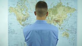 Un homme regarde une carte du monde clips vidéos Un homme regarde une carte du monde clips vidéos