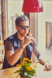 Un homme s'assied à la table dans un café photo libre de droits Un homme s'assied à la table dans un café photo libre de droits
