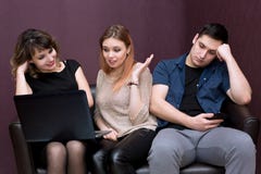 Un homme s'ennuie avec deux filles observant un film image stock Un homme s'ennuie avec deux filles observant un film image stock