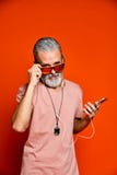 Un'immagine di un uomo anziano che ascolta la musica con le cuffie immagini stock libere da diritti Un'immagine di un uomo anziano che ascolta la musica con le cuffie immagini stock libere da diritti