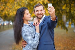 Un individuo hace el selfie con una muchacha contra el contexto de un parque del otoño fotos de archivo libres de regalías Un individuo hace el selfie con una muchacha contra el contexto de un parque del otoño fotos de archivo libres de regalías