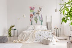Un intérieur écologique lumineux de chambre à coucher avec un lit s'habille en toile de blanc de modèle de plantes vertes Tissu p image libre de droits Un intérieur écologique lumineux de chambre à coucher avec un lit s'habille en toile de blanc de modèle de plantes vertes Tissu p image libre de droits