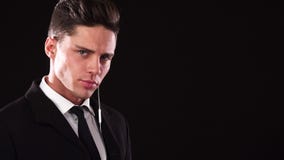 Un jeune type met dessus un écouteur et ressemble à un garde du corps sérieux photo stock Un jeune type met dessus un écouteur et ressemble à un garde du corps sérieux photo stock