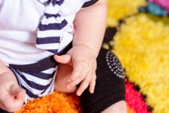 Un joli bébé dans une chemise rayée et des chapeaux posés sur le tapis dans la chambre photo stock Un joli bébé dans une chemise rayée et des chapeaux posés sur le tapis dans la chambre photo stock