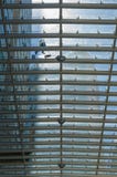 Un lavoratore pulisce il tetto di vetro di un centro commerciale in ci del Messico fotografia stock libera da diritti Un lavoratore pulisce il tetto di vetro di un centro commerciale in ci del Messico fotografia stock libera da diritti