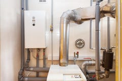Un locale caldaie domestico della famiglia con una nuova caldaia moderna del combustibile solido, un sistema a acqua caldo elettr immagine stock libera da diritti Un locale caldaie domestico della famiglia con una nuova caldaia moderna del combustibile solido, un sistema a acqua caldo elettr immagine stock libera da diritti