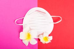 Un masque protecteur sur le fond rose et rouge avec les fleurs exotiques Images libres de droits Un masque protecteur sur le fond rose et rouge avec les fleurs exotiques Images libres de droits