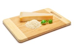 Un morceau de parmesan et de fromage râpé sur le fond de blanc de planche à découper Image stock Un morceau de parmesan et de fromage râpé sur le fond de blanc de planche à découper Image stock