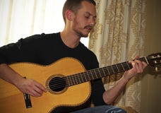 Un musicista Plays una chitarra acustica classica Fotografia Stock Libera da Diritti Un musicista Plays una chitarra acustica classica Fotografia Stock Libera da Diritti