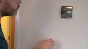 Un m?le blanc utilise un thermostat ?lectronique de ruche dans une maison banque de vidéos Un m?le blanc utilise un thermostat ?lectronique de ruche dans une maison banque de vidéos