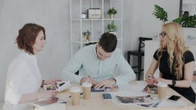 Un patron femelle ambitieux et attrayant agit l'un sur l'autre avec deux dessinateurs d'intérieurs dans l'immeuble de bureaux mod banque de vidéos Un patron femelle ambitieux et attrayant agit l'un sur l'autre avec deux dessinateurs d'intérieurs dans l'immeuble de bureaux mod banque de vidéos