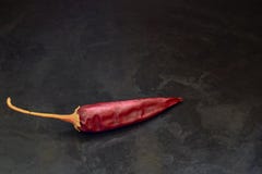 Un peperone amaro del baccello su un fondo nero fotografia stock Un peperone amaro del baccello su un fondo nero fotografia stock