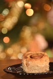 Un petit pain de cannelle avec le bokeh de Chrismas à l'arrière-plan photo libre de droits Un petit pain de cannelle avec le bokeh de Chrismas à l'arrière-plan photo libre de droits