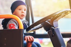 Un piccolo bello bambino che si siede nel bus e che gioca driver Front View fotografie stock libere da diritti Un piccolo bello bambino che si siede nel bus e che gioca driver Front View fotografie stock libere da diritti