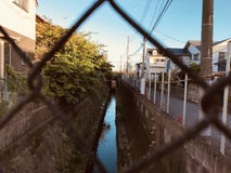 Un piccolo fiume situato fra le case nel Giappone fotografia stock Un piccolo fiume situato fra le case nel Giappone fotografia stock