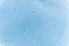 Un plan rapproché de la surface d'un fragment d'un glacier avec une structure des bandes et des bulles entremêlées avec le sable photographie stock libre de droits Un plan rapproché de la surface d'un fragment d'un glacier avec une structure des bandes et des bulles entremêlées avec le sable photographie stock libre de droits