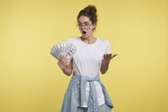 Un portrait de femme choquée de brune, elle peut le ` t la croire a tellement l'argent dans la main photographie stock libre de droits Un portrait de femme choquée de brune, elle peut le ` t la croire a tellement l'argent dans la main photographie stock libre de droits