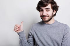 Un portrait horizontal de hippie barbu élégant avec la coiffure à la mode étant positif s'est habillé dans le chandail gris occas image libre de droits Un portrait horizontal de hippie barbu élégant avec la coiffure à la mode étant positif s'est habillé dans le chandail gris occas image libre de droits