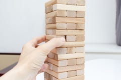 Un ragazzo caucasico preteen che gioca il gioco da tavolo di legno della torre del blocco per la pratica la suoi abilit? e spetta fotografie stock libere da diritti Un ragazzo caucasico preteen che gioca il gioco da tavolo di legno della torre del blocco per la pratica la suoi abilit? e spetta fotografie stock libere da diritti