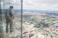 Un ragazzo guarda fuori dal balcone trasparente della torre di willis del Th fotografie stock Un ragazzo guarda fuori dal balcone trasparente della torre di willis del Th fotografie stock