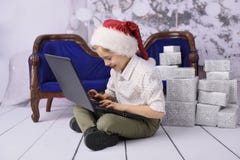 Un ragazzo sorridente come Santa Claus con un albero di Natale nei precedenti immagini stock Un ragazzo sorridente come Santa Claus con un albero di Natale nei precedenti immagini stock