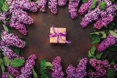 Un ramo de lilas con la caja de regalo en fondo oxidado Día del `s de la madre foto de archivo libre de regalías Un ramo de lilas con la caja de regalo en fondo oxidado Día del `s de la madre foto de archivo libre de regalías