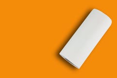 Un rotolo completo dell'asciugamano di carta o della carta molle bianco per la toilette sulla tavola arancio con lo spazio della fotografia stock Un rotolo completo dell'asciugamano di carta o della carta molle bianco per la toilette sulla tavola arancio con lo spazio della fotografia stock