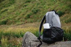 Un sac à dos, une tasse, un bloc-notes et une carte se trouvent sur l'herbe Équipement de touristes La pomme se situe dans la poc photo libre de droits Un sac à dos, une tasse, un bloc-notes et une carte se trouvent sur l'herbe Équipement de touristes La pomme se situe dans la poc photo libre de droits