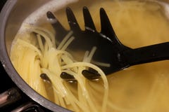 Un server della pasta sostiene i una coppia di semi ha cucinato le paglie degli spaghetti fotografia stock libera da diritti Un server della pasta sostiene i una coppia di semi ha cucinato le paglie degli spaghetti fotografia stock libera da diritti