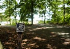 Un signe par un chemin forestier Image libre de droits Un signe par un chemin forestier Image libre de droits