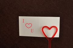 Un supporto di nota con un cuore rosso con una nota immagini stock libere da diritti Un supporto di nota con un cuore rosso con una nota immagini stock libere da diritti