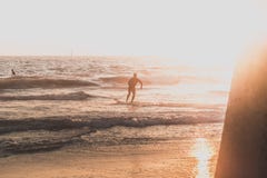 Un surfista che corre sulla spiaggia immagini stock Un surfista che corre sulla spiaggia immagini stock