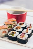 Un sushi fijó con los palillos del cuenco y del bambú de la salsa en el fondo blanco Imagen de archivo libre de regalías Un sushi fijó con los palillos del cuenco y del bambú de la salsa en el fondo blanco Imagen de archivo libre de regalías