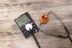 Un tournevis rouge traite un disque dur cassé avec le stéthoscope image libre de droits Un tournevis rouge traite un disque dur cassé avec le stéthoscope image libre de droits